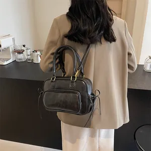 Vintage black leather backpack for women shown on model in a stylish coffee shop setting