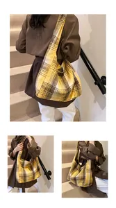 Detail view of a large yellow plaid wool tote bag styled on a shoulder in autumn