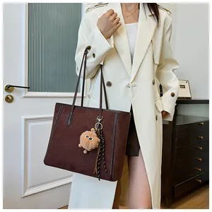 Brown suede tote bag shown on a model in a stylish interior setting for daily use