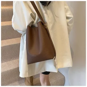 Detailed view of the brown leather bucket bag texture and embossed fashion lettering