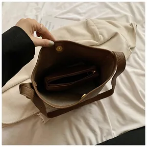 Close-up of coffee brown lychee textured bucket bag with magnetic closure and inner pouch