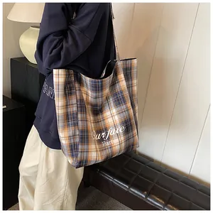 Detail of yellow plaid tote bag with orange and blue check and 'Our fave Party' text