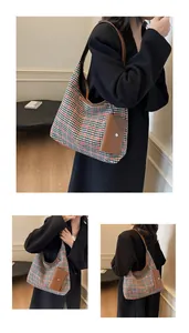 Macro view of hobo bag featuring houndstooth fabric with premium brown leather trim