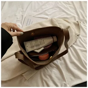 Interior detail of coffee brown pebbled leather bucket bag showing capacity and zip pocket