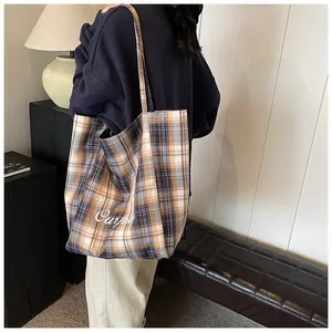 Detailed back view of a yellow plaid canvas tote bag with artistic letter printing