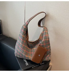 Detail of colorful houndstooth hobo bag with brown leather strap and small pouch