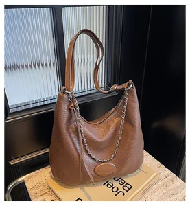 Dettaglio borsa tote marrone trama litchi con catena argento e nappina in pelle