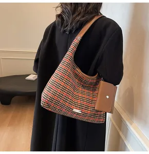 Detail of houndstooth shoulder bag featuring a mini pouch and brown leather trim