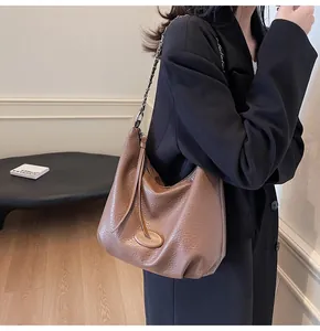 Dettaglio borsa hobo in pelle martellata marrone scuro con catena e nappa
