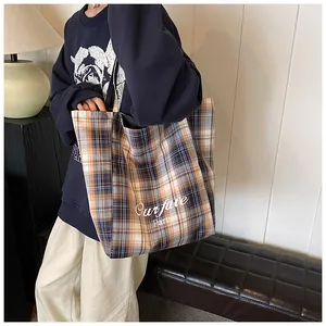 Detail of yellow and blue plaid tote bag with Ourfave Party print for casual look