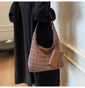 Detail of red houndstooth tweed shoulder bag with brown leather trim and mini purse