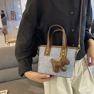 Schicke graue Denim Mini-Tote mit braunem Lederbesatz und süßem Welpenanhänger