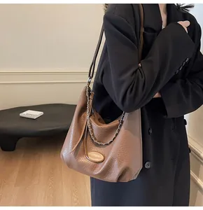 Dettaglio borsa hobo in pelle martellata marrone con catena argento e tracolla fine