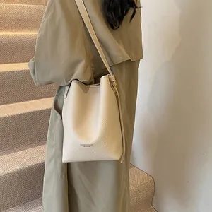 Chic beige lychee grain bucket bag with FASHION & BAGS print and adjustable strap