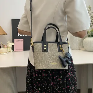 Minimalistische Shopper-Tasche mit Marmormuster, schwarzen Griffen und Bärenanhänger