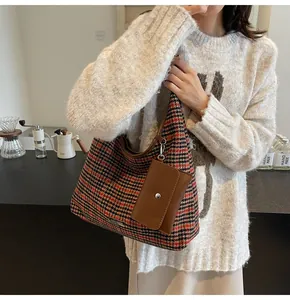 Detail of vintage houndstooth tote bag with small leather coin purse in soft indoor light