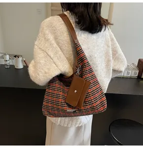 Detail of vintage houndstooth shoulder bag with matching brown leather strap and pouch
