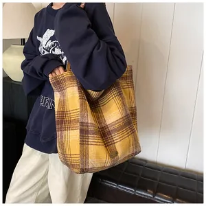 Detailed texture of yellow plaid wool tote bag showing premium fabric and logo emblem