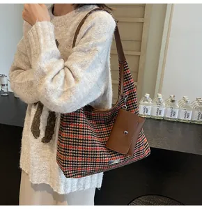 Detail of red houndstooth tote bag with leather strap and mini coin purse attachment