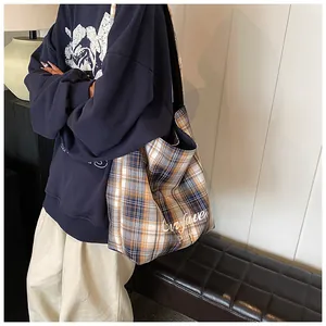 Detail view of large plaid tote bag side depth and white cursive text print