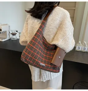 Detail of houndstooth shoulder bag in brown and black with a small leather coin purse