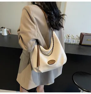 Dettaglio borsa hobo in pelle martellata bianco sporco con catena e nappa decorativa