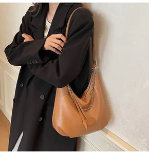 Dettaglio borsa hobo color caramello con trama a grana e catena decorativa in argento