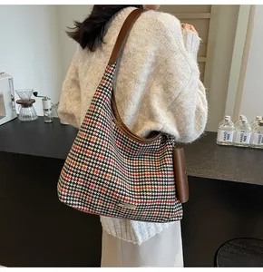 Detail of houndstooth shoulder bag with mini side pouch and brown leather strap