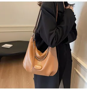 Dettaglio della borsa hobo color cammello con pelle granata, catena e nappa lunga