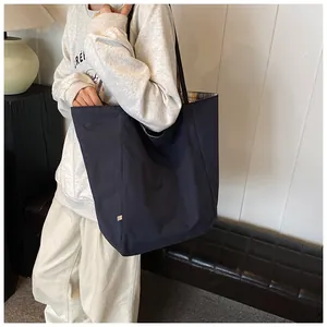 Detail of large tote bag showing navy exterior and yellow plaid pattern inner lining