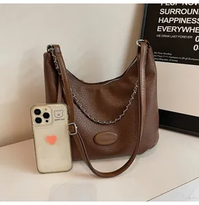 Dettaglio borsa hobo marrone caffè in pelle martellata con catena e scala dimensionale