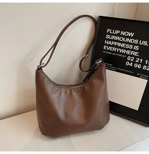 Dettaglio della borsa tote in pelle marrone caffè con trama litchi e zip argentata