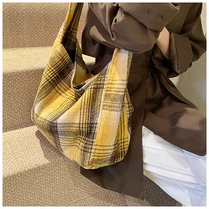 Detailed view of yellow plaid wool tote bag showing large capacity on model's shoulder