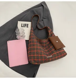 Detail of houndstooth hobo bag with brown leather strap and small detachable card pouch