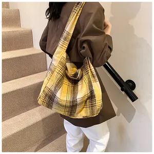 Macro detail of the yellow and brown plaid tote bag featuring thick wool texture
