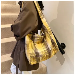 Detail of yellow plaid wool tote bag showing thick texture and wide shoulder strap