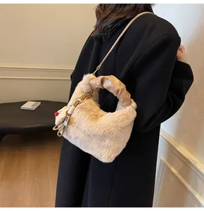 Detailansicht der flauschigen Kunstfell-Beuteltasche mit Ledergriff und Katzenanhänger