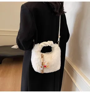 Rückansicht eines Modells mit einer weißen Plüschtasche und einem niedlichen Bärenanhänger