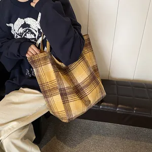 Large yellow plaid wool tote bag for autumn and winter being carried in a home setting