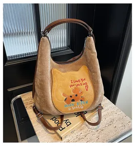 Détail du sac cabas en suédine marron avec broderie chat et bandoulière en cuir