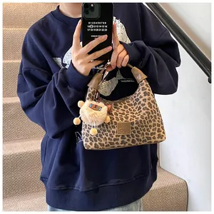 Detail of leopard print faux fur handbag featuring a plush sheep charm and vintage style