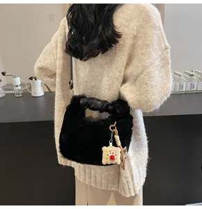 Details der schwarzen Plüsch-Eimertasche mit Toast-Anhänger und PU-Ledergriff