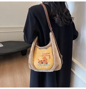 Vue détaillée du sac cabas en velours marron avec poche chat et broderies de luxe