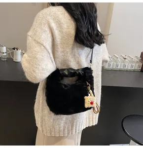 Detail der schwarzen flauschigen Beuteltasche mit Toast-Plüsch-Anhänger und Ledergriff