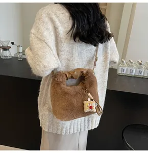 Detail der hellbraunen Plüschtasche mit Ledergriff und Brot-Anhänger Motiv