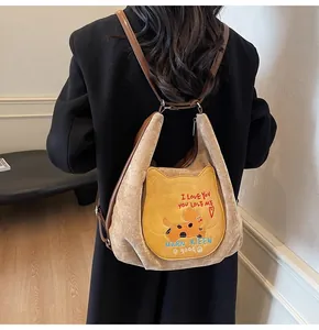 Détail d'un sac à dos fourre-tout avec broderie de chien et poche jaune en forme d'oreilles