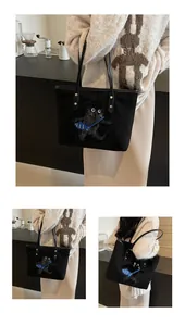 Close-up of black canvas tote bag featuring cute cat and fish embroidery detail