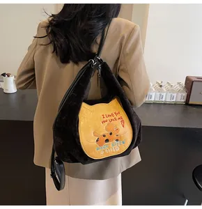 Détail du sac cabas en velours noir avec écusson chat jaune et broderie chiot