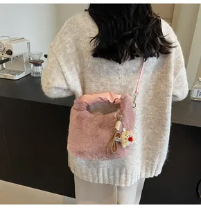 Detail der rosa Plüsch-Beuteltasche mit Bärenanhänger und gerafftem Tragegriff