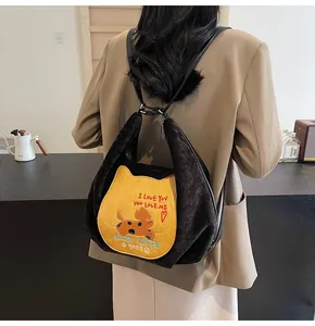 Vue détaillée d'un sac à dos en velours noir avec écusson chat jaune et lanières cuir